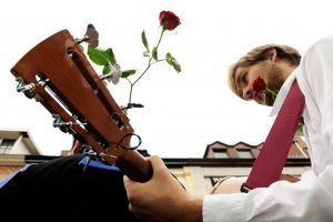 Man playing guitar and handing out roses